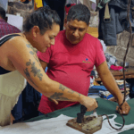 Traveler observing local garment workshop during a guided cultural tour in Dharavi Mumbai