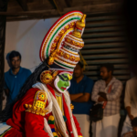 Kathakali dancer in traditional costume preparing for a performance in Kerala