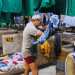 Local washerman cleaning clothes in an open-air traditional laundry facility in Mumbai