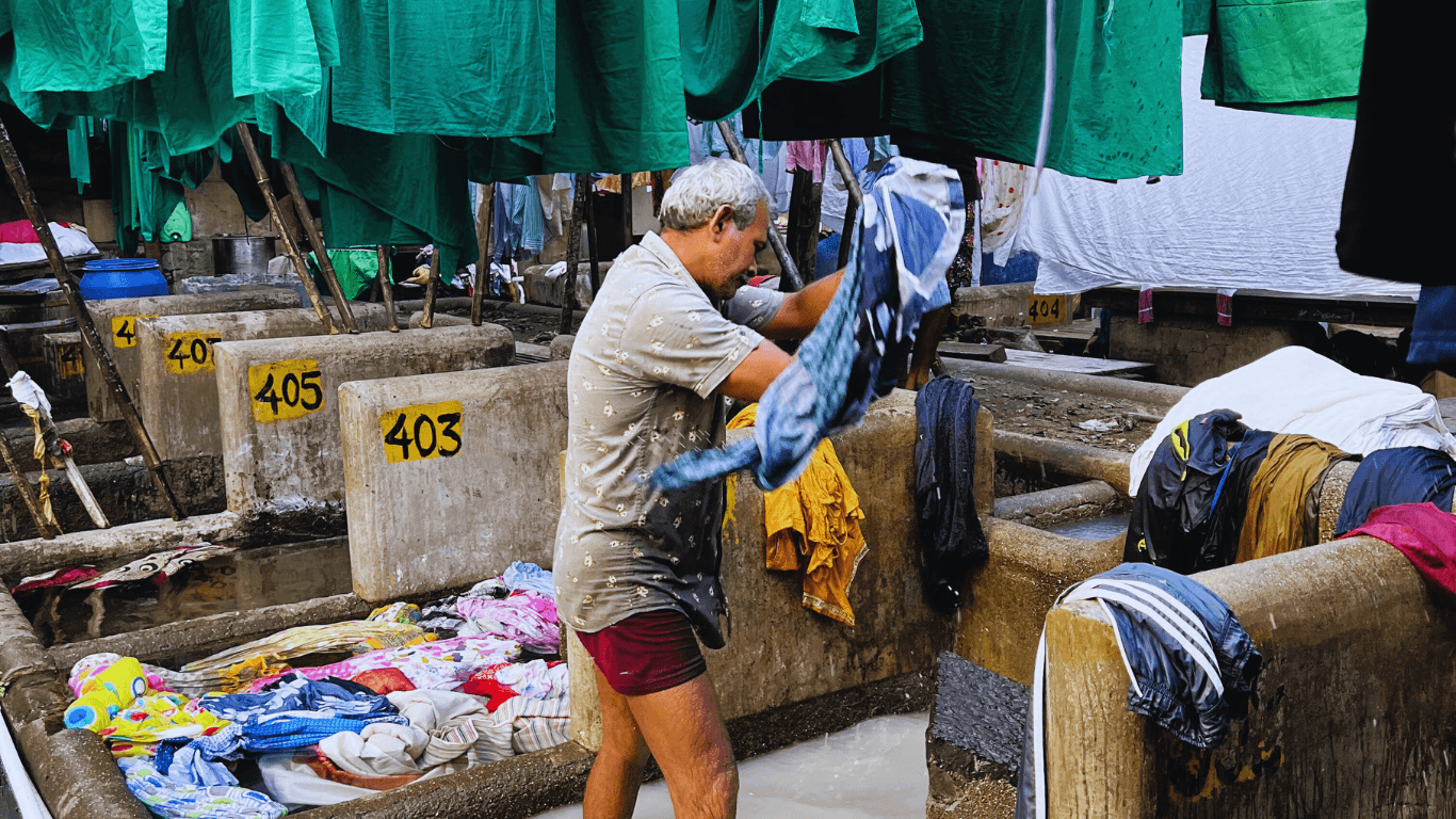 Local washerman cleaning clothes in an open-air traditional laundry facility in Mumbai