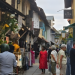 Tourists walking through a heritage market street in Kerala