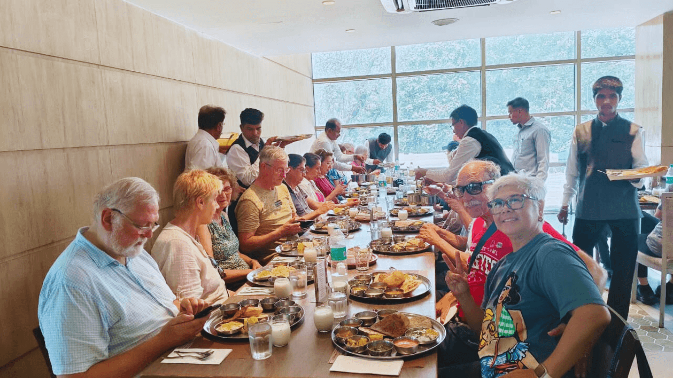Tour group enjoying a traditional Indian thali lunch at a restaurant during a guided Mumbai sightseeing tour