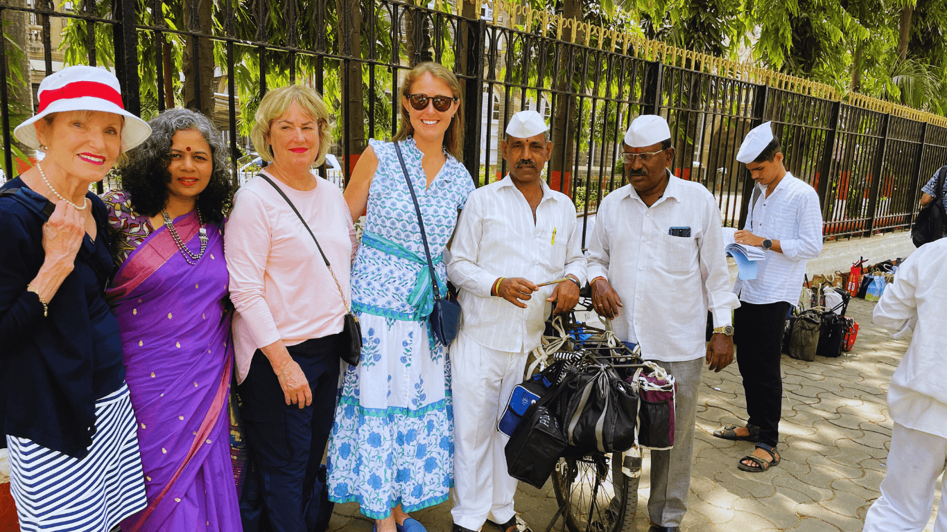 Travelers meeting Mumbai dabbawalas during a cultural walking tour experience in Mumbai