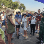 Tour guide explaining local history to a group of travelers during a guided walking tour in Mumbai.