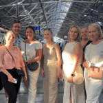 Group of international travelers posing inside a busy Mumbai railway station during a guided city tour.