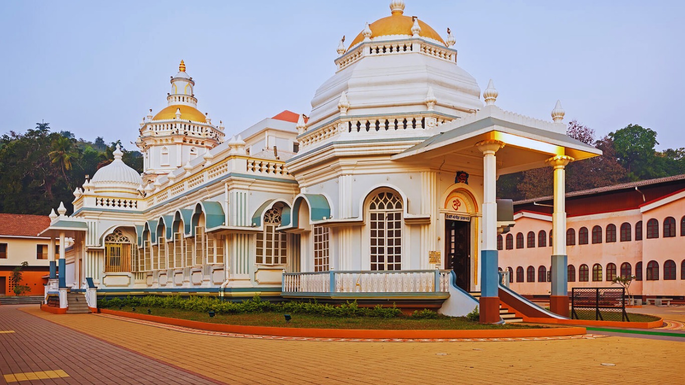 Traditional Hindu temple in Goa with white domes and golden spires
