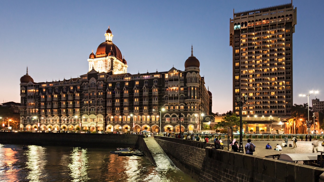 Taj Mahal Palace Hotel Mumbai illuminated at dusk near Gateway of India