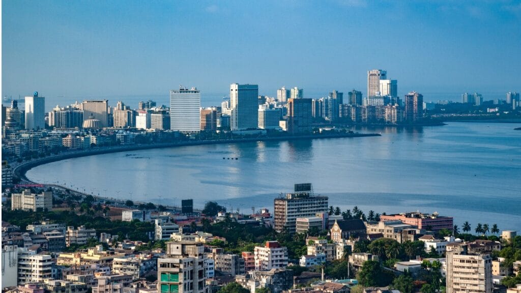 Mumbai skyline at Marine Drive during blue hour with city buildings and curved coastline