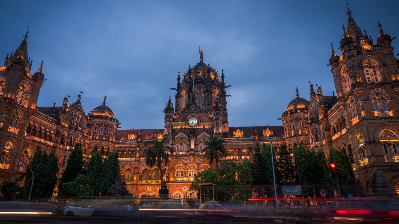 Chhatrapati Shivaji Maharaj Terminus illuminated at night with traffic trails and historic architecture