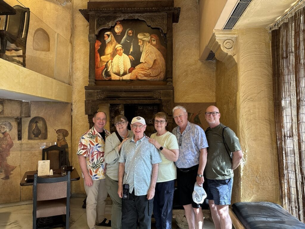 Small group of travelers posing inside a historic heritage interior during a cultural sightseeing experience in Mumbai.